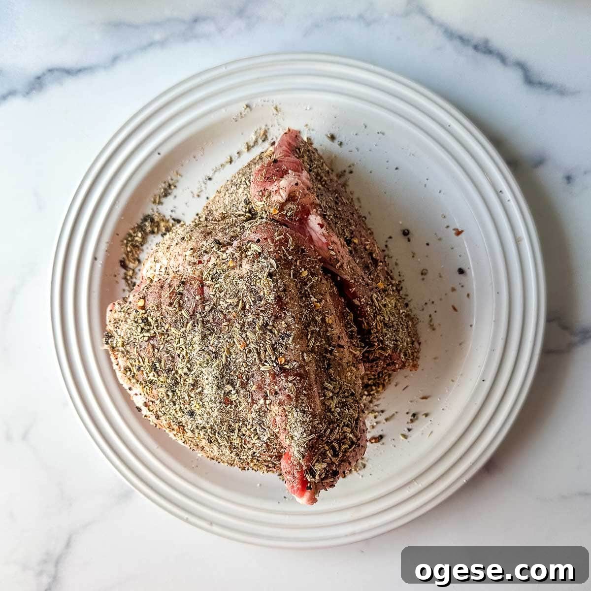 Slow Cooker Italian Pork Roast with Garlic and Herbs 9 A pork butt on a plate with spices on it.