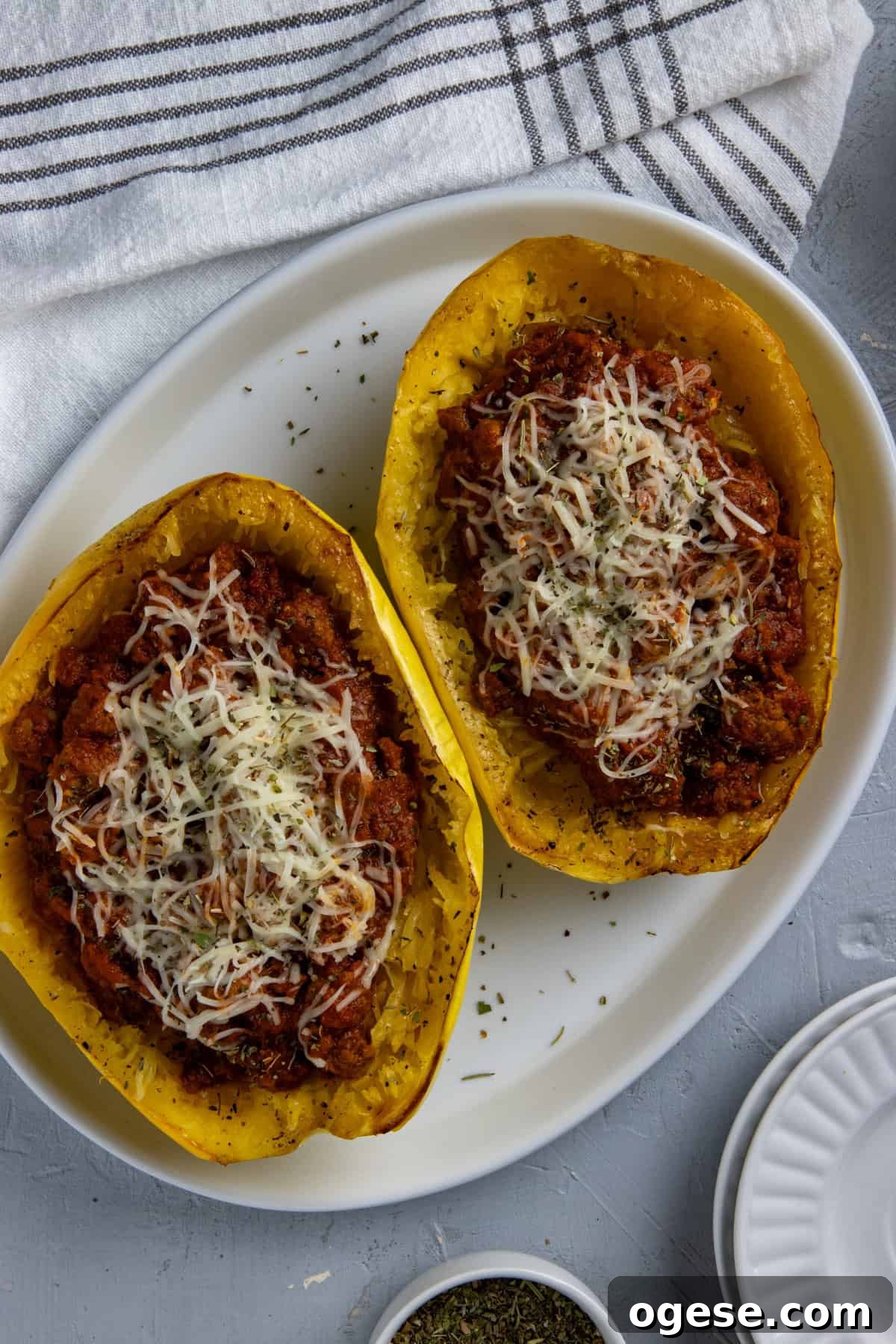 Cheesy Stuffed Spaghetti Squash with Herbs and Parmesan 2 Two roasted spaghetti squash halves topped with spaghetti sauce and mozzarella cheese.