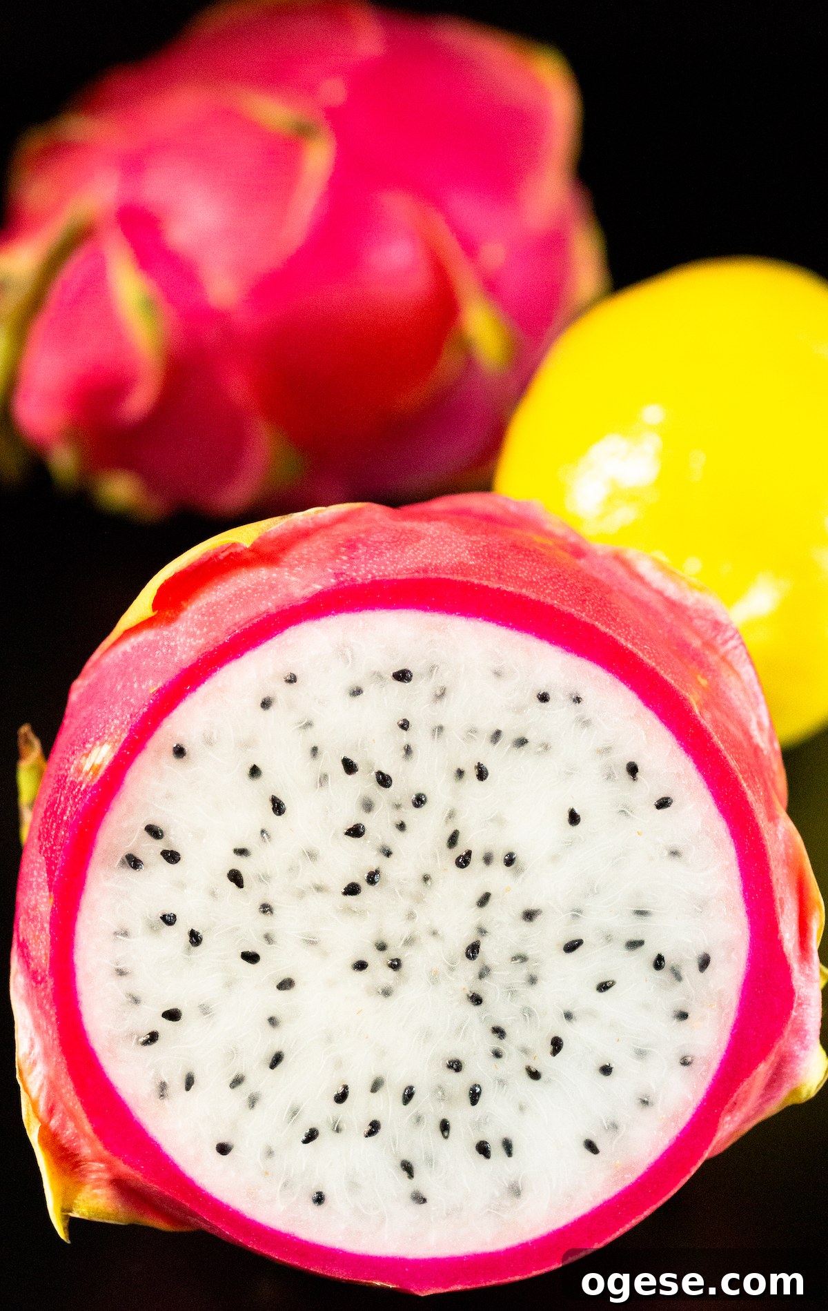 Dehydrated Dragon Fruit Chips: DIY Recipe and Storage Tips 3 A dragonfruit sliced in half to show the white flesh inside sits in front if a lemon and an uncut dragonfruit.