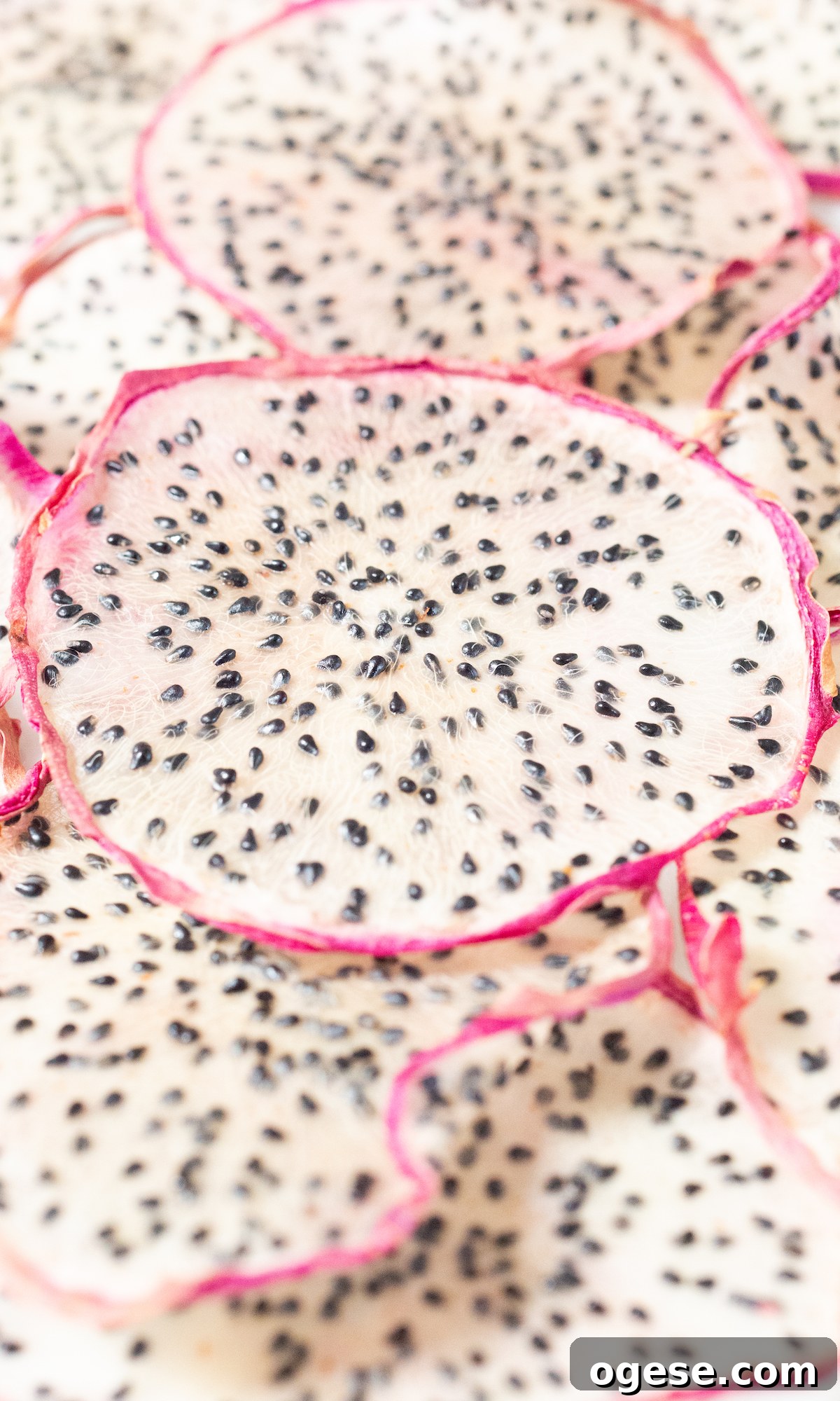 Dehydrated Dragon Fruit Chips: DIY Recipe and Storage Tips 8 Dozens of slices of dehydrated dragon fruit on a white platter.