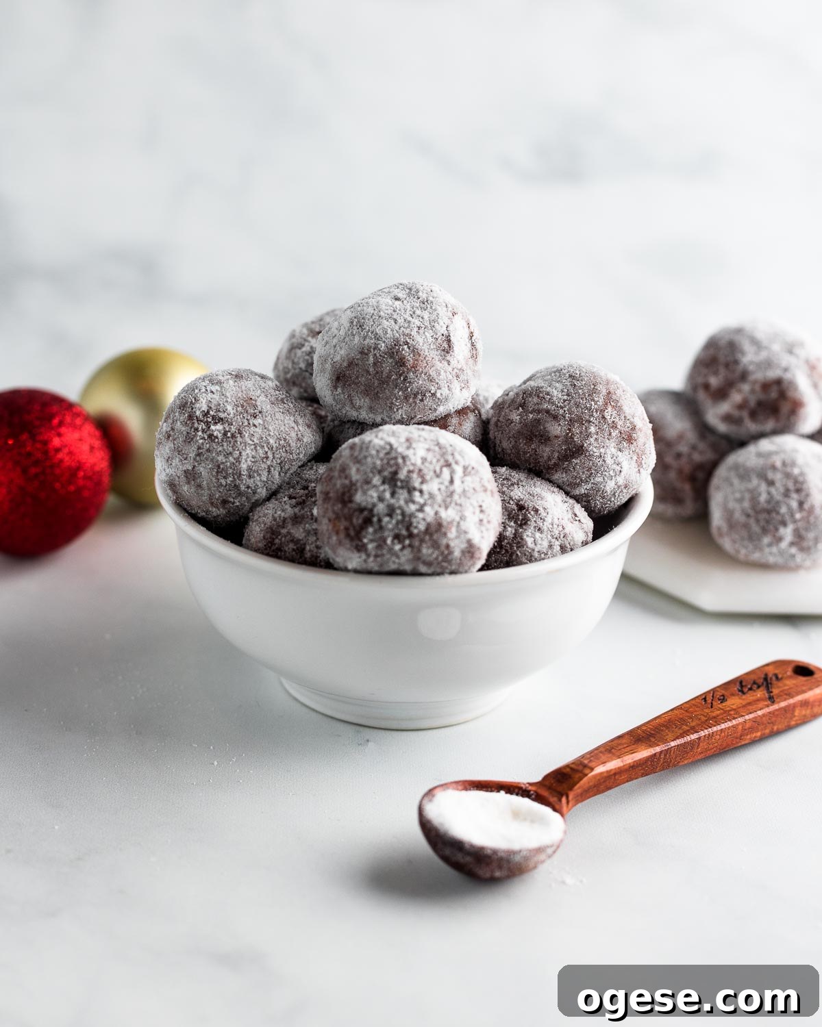A bowl with muddy buddy snowball treats, and xmas ornaments in the background.