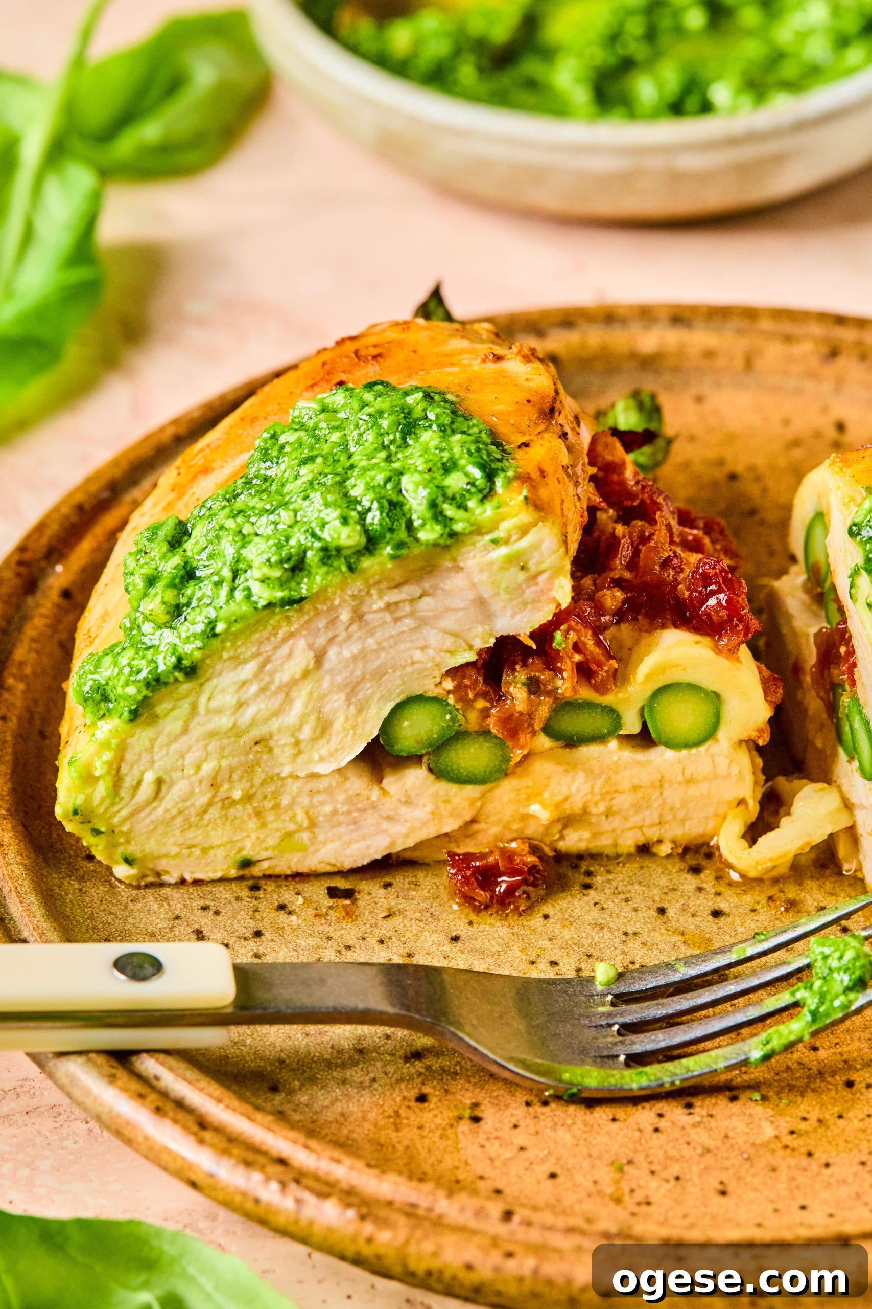 A cheesy asparagus stuffed chicken breast cut in half to reveal the melty, cheesy inside