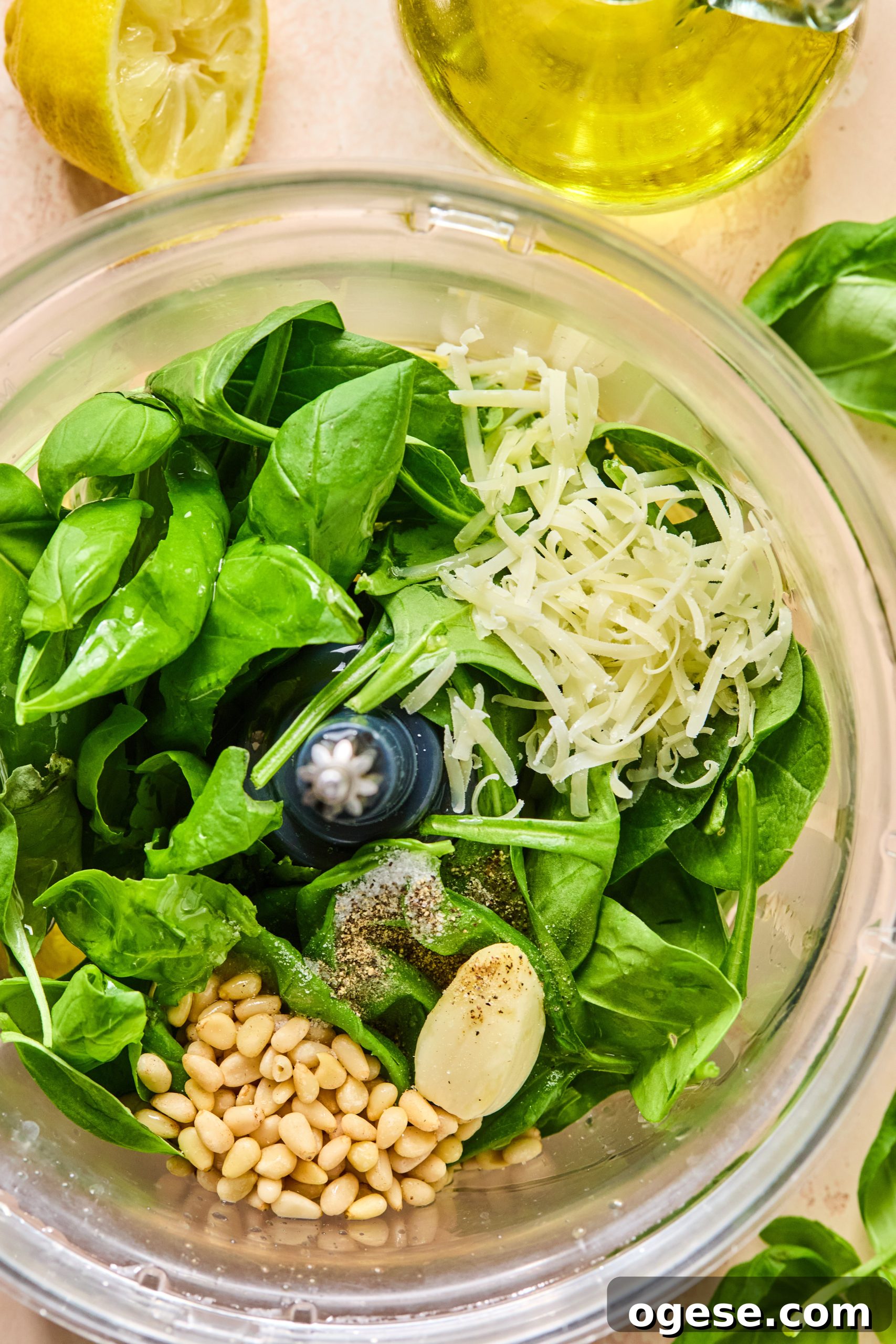 A food processor filled with ingredients used to make homemade spinach basil pesto
