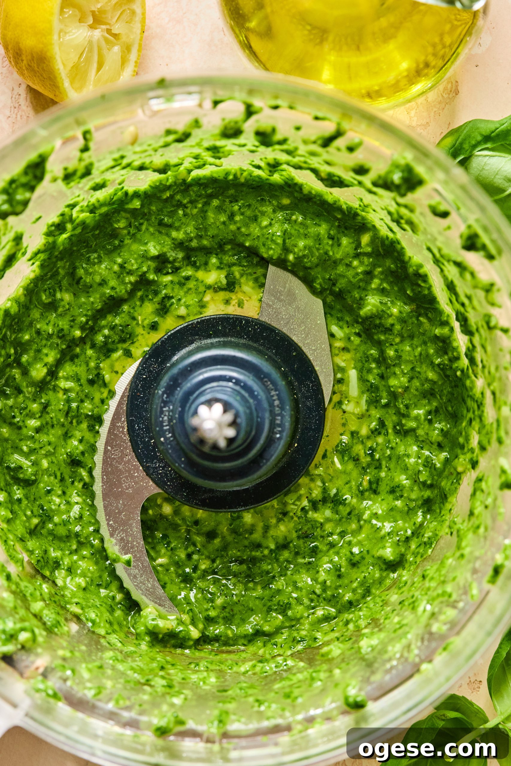 A food processor filled with homemade spinach pesto