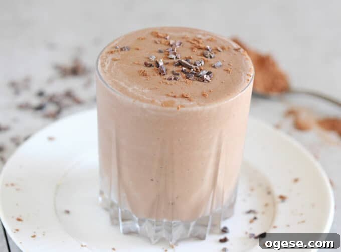 Creamy Chocolate Peanut Butter Banana Smoothie 2 Chocolate smoothie in a glass on a white plate.