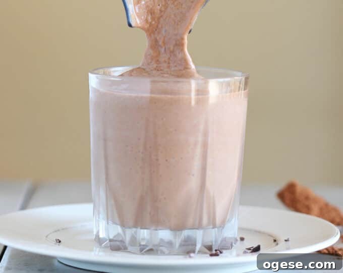 Creamy Chocolate Peanut Butter Banana Smoothie 6 Chocolate smoothie being poured into a glass.