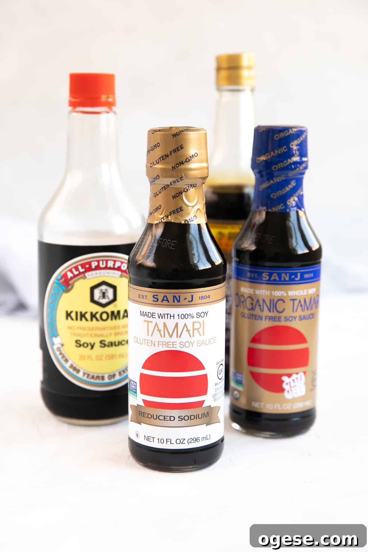 Bottles of soy sauce and tamari set on a table.