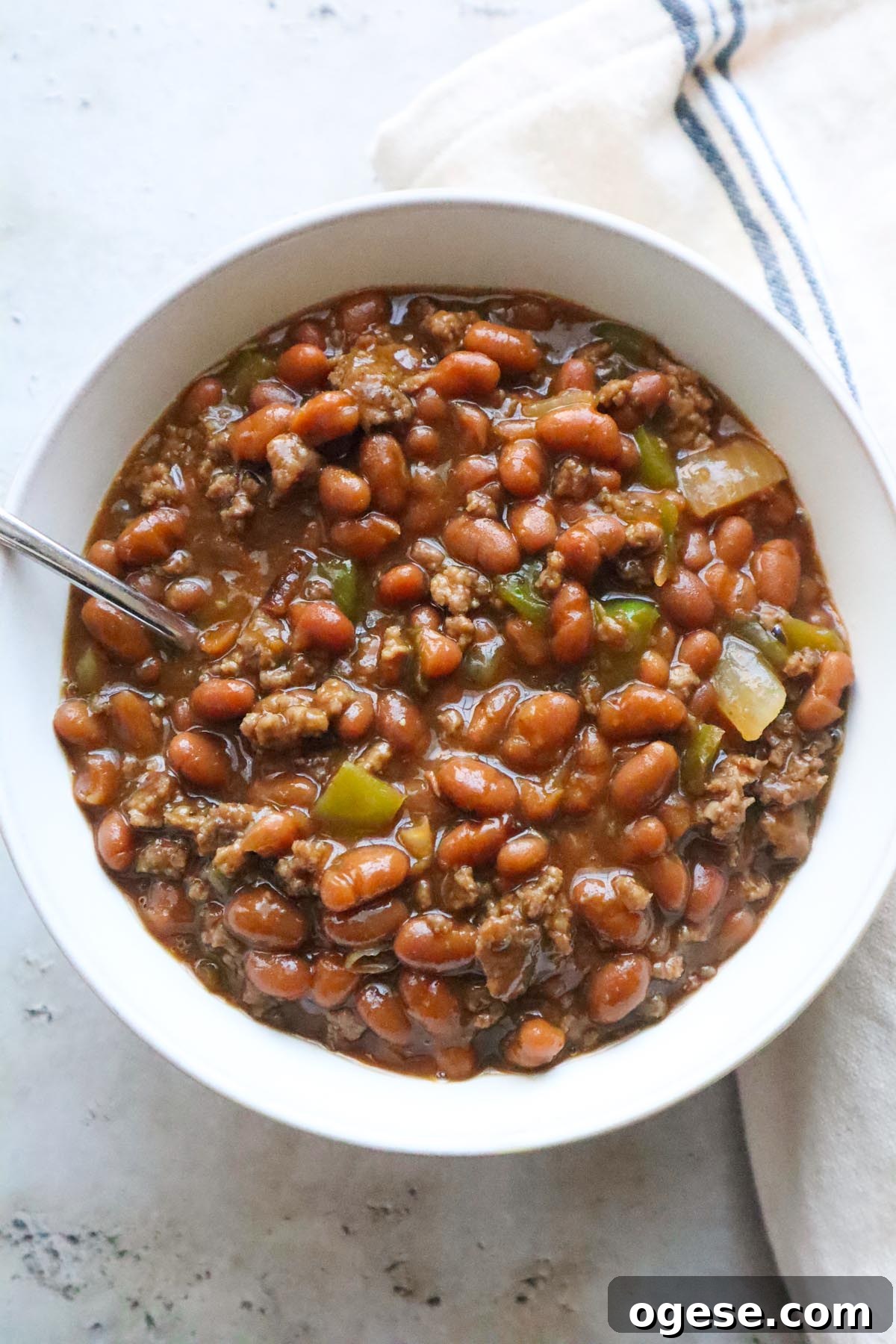 white bowl with baked beans and ground beef.