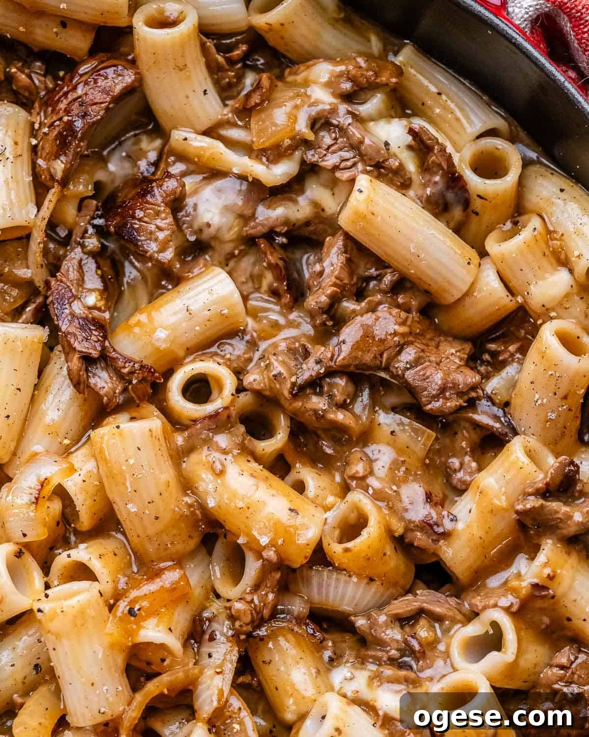 Creamy Philly Cheesesteak Pasta with Peppers & Onions 9 A closeup of Philly cheesesteak pasta in a cast iron skillet